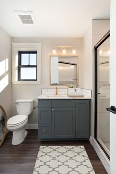 a bathroom with a toilet, sink and shower