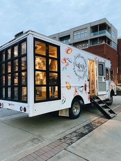 the food truck is parked on the side of the road in front of a building