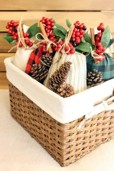 a basket filled with pine cones, berries and other holiday decorations on top of a table