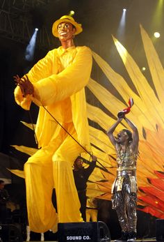 two performers are performing on stage with their hands in the air