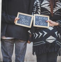 two people standing next to each other holding signs that say, one year to go