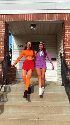 two women in matching outfits are walking down the stairs