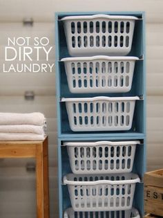 three white laundry baskets stacked on top of each other in front of a blue shelf