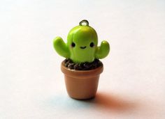 a small green cactus in a clay pot with its eyes closed, sitting on a white surface