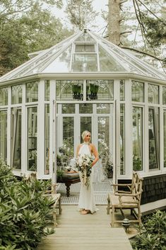 a woman standing in front of a glass house