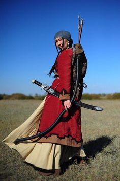 a woman dressed in medieval clothing holding two swords