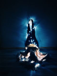 two women are dancing in the dark with lights