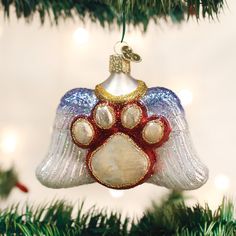 a glass ornament with a dog's paw on it hanging from a christmas tree