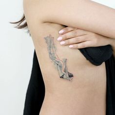 a woman with a tattoo on her back holding onto a black object in front of her