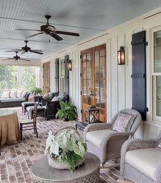 a porch with wicker furniture and plants on it