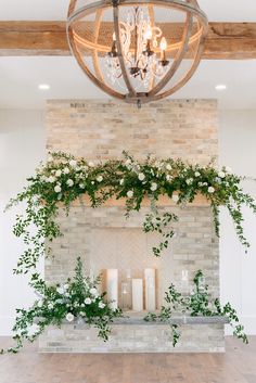 the fireplace is decorated with greenery and candles for an elegant touch to the room