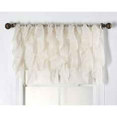 a curtain with ruffles hanging on the side of a window sill in front of a white wall