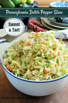 a bowl filled with coleslaw and carrots on top of a wooden table