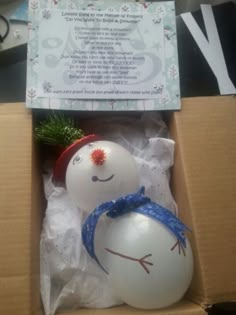 two snowmen in a box with a christmas tree ornament on the top