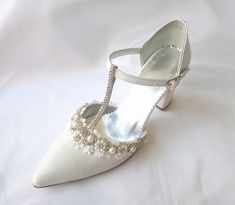 Combining style with comfort, this white elegant wedding court shoe is featuring sparkling crystal and pearl embellishment at the front of the shoe finished with a 7,5cm block heel and a delicate ankle strap. This leather bridal shoe is completely handmade and embroidered by hand with pearls and excellent quality crystals. The luxurious leather lining is cushioned in all the right places to ensure ultimate comfort. A timeless and classic wedding shoe with a touch of modern elegance! *Genuine whi Classic Wedding Shoes, Wedding Shoes For Bride, Shoes For Bride, Jeweled Shoes, Wedding Court, Wedding Shoes Flats, Shoes Handmade, Wedding Sandals, Womens Wedding Shoes