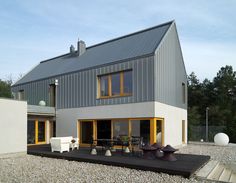 a modern house with an outdoor deck and seating area