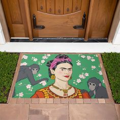 a door mat with an image of fridace and monkeys on it in front of a wooden door