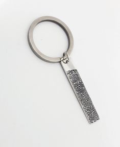 a metal keychain with a fingerprint on the front and back part of it