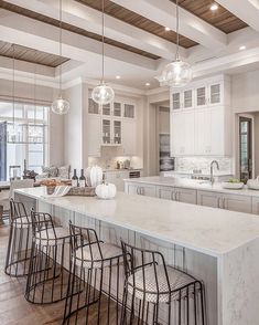 a large kitchen with an island in the middle and lots of stools around it