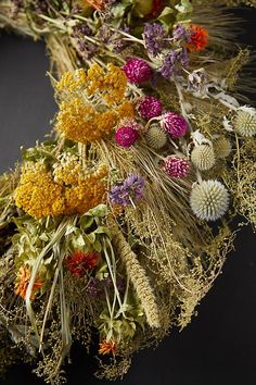 an arrangement of dried flowers on a black background