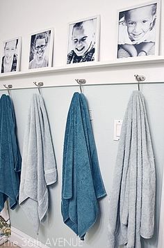 towels are hanging on the wall in front of pictures and other personalized items,