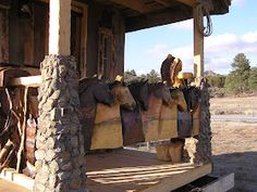 an outdoor area with logs and other items on the porch, in front of a building