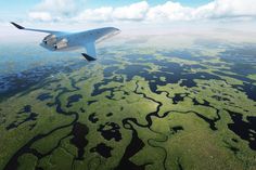 an airplane flying over land and water in the sky