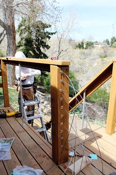 a man on a ladder working on a wooden structure