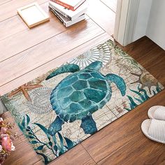 a sea turtle rug on the floor next to a pair of slippers and books