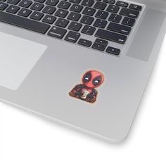 a laptop computer with a deadpool sticker on the keyboard