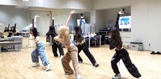 group of young people dancing in a dance studio with one person holding up her arms