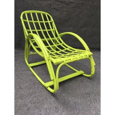 a bright green rocking chair sitting on top of a gray carpeted floor next to a black wall