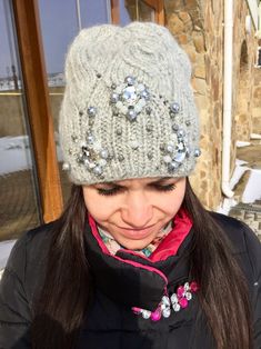 a woman wearing a gray knitted hat with sequins