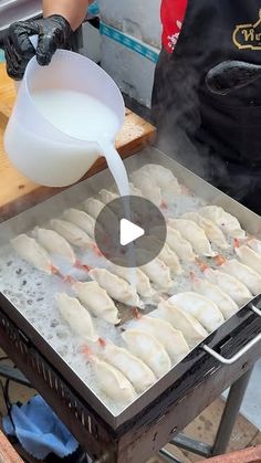 a person pouring milk on top of some dumplings