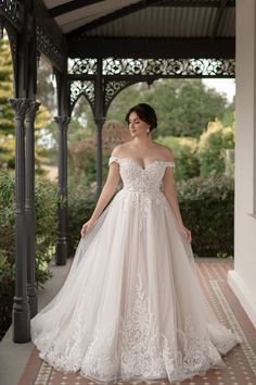 a woman in a wedding dress standing on a porch