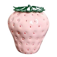 a pink ceramic strawberry with a green bow on it's top, sitting in front of a white background