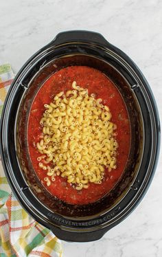 a crock pot filled with macaroni and cheese on top of a table