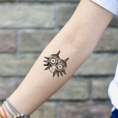 a woman's arm with a tattoo on it that has an owl in the middle