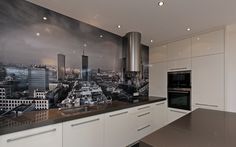 a kitchen with black and white cityscape painted on the wall next to an oven