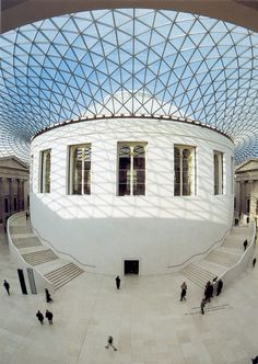 the inside of a building with people walking around and looking up at it's ceiling