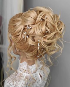 a woman with long blonde hair wearing a wedding hairstyle and pearls in her hair