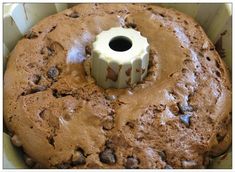 a cake in a pan with chocolate chips on top and a white frosting ring