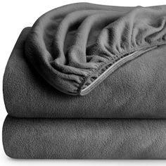 two blankets are folded on top of each other, one is gray and the other is white