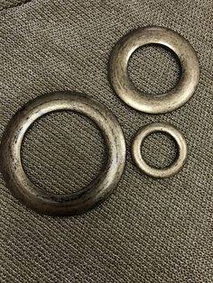 three metal rings sitting on top of a brown cloth