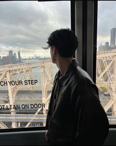 a man standing in front of a window looking out at a bridge and the words teach your step not lean on door