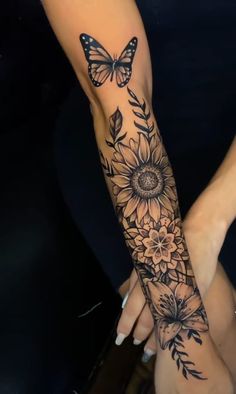 a woman's arm with sunflowers and butterflies on it