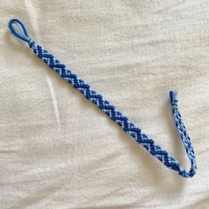 a blue and white braided object laying on top of a bed