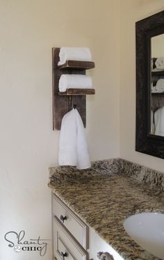 a bathroom with marble counter tops and white towels hanging on the rack above the sink