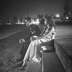 a man and woman sitting on a bench at night