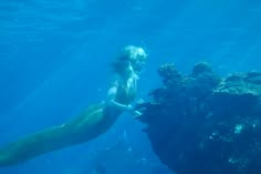 a young boy is swimming in the ocean with a large seaweed on it's back